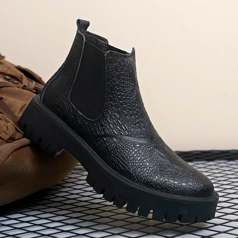 Black genuine leather men's Chelsea boots with textured upper, thick rubber sole, and midsole featuring big toe design